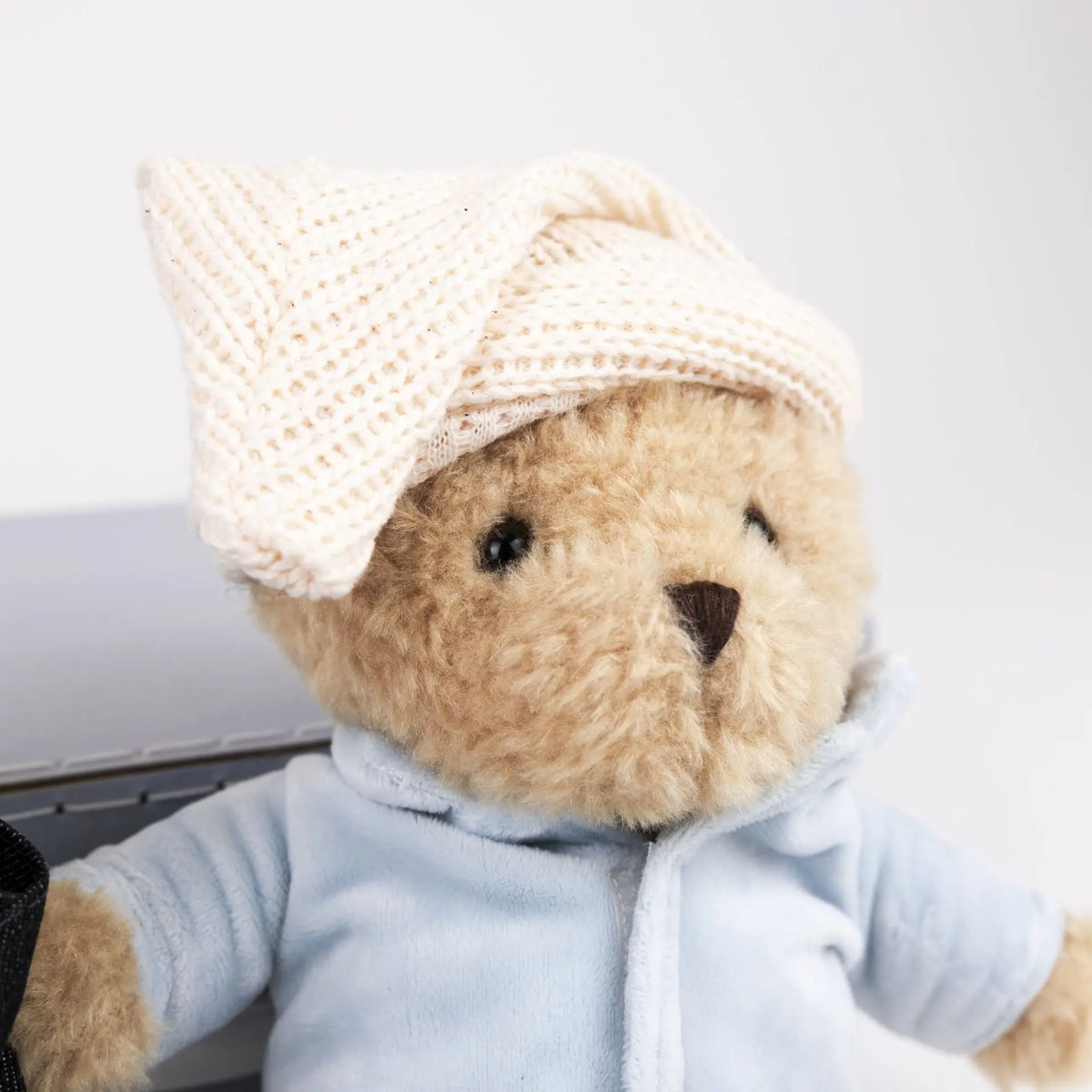 Morris bear with clothes in a case