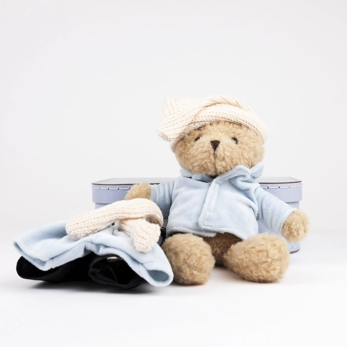 Morris bear with clothes in a case