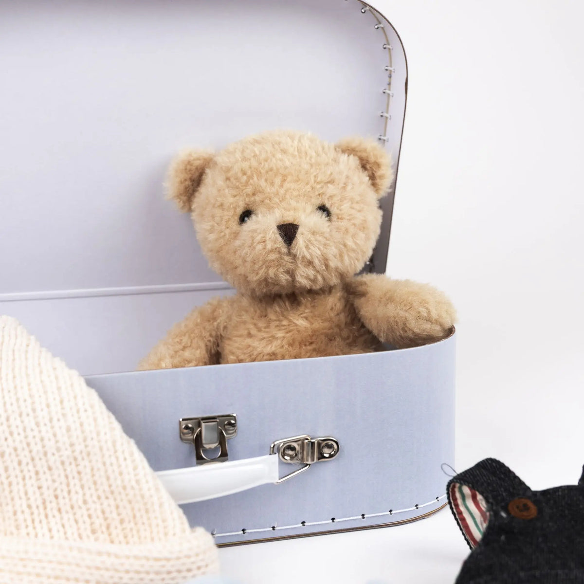 Morris bear with clothes in a case